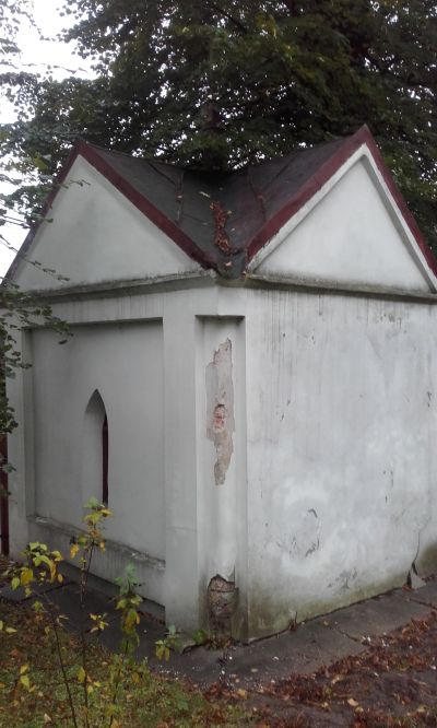 Rok 2014. Ujęcie kapliczki od strony ogrodu. Widać zawilgocenia ścian i wypraw tynkarskich, ich zmurszałość, spękania, miejscowe ubytki i odspajanie od wątku. Fot. ze zbior&oacute;w autorki